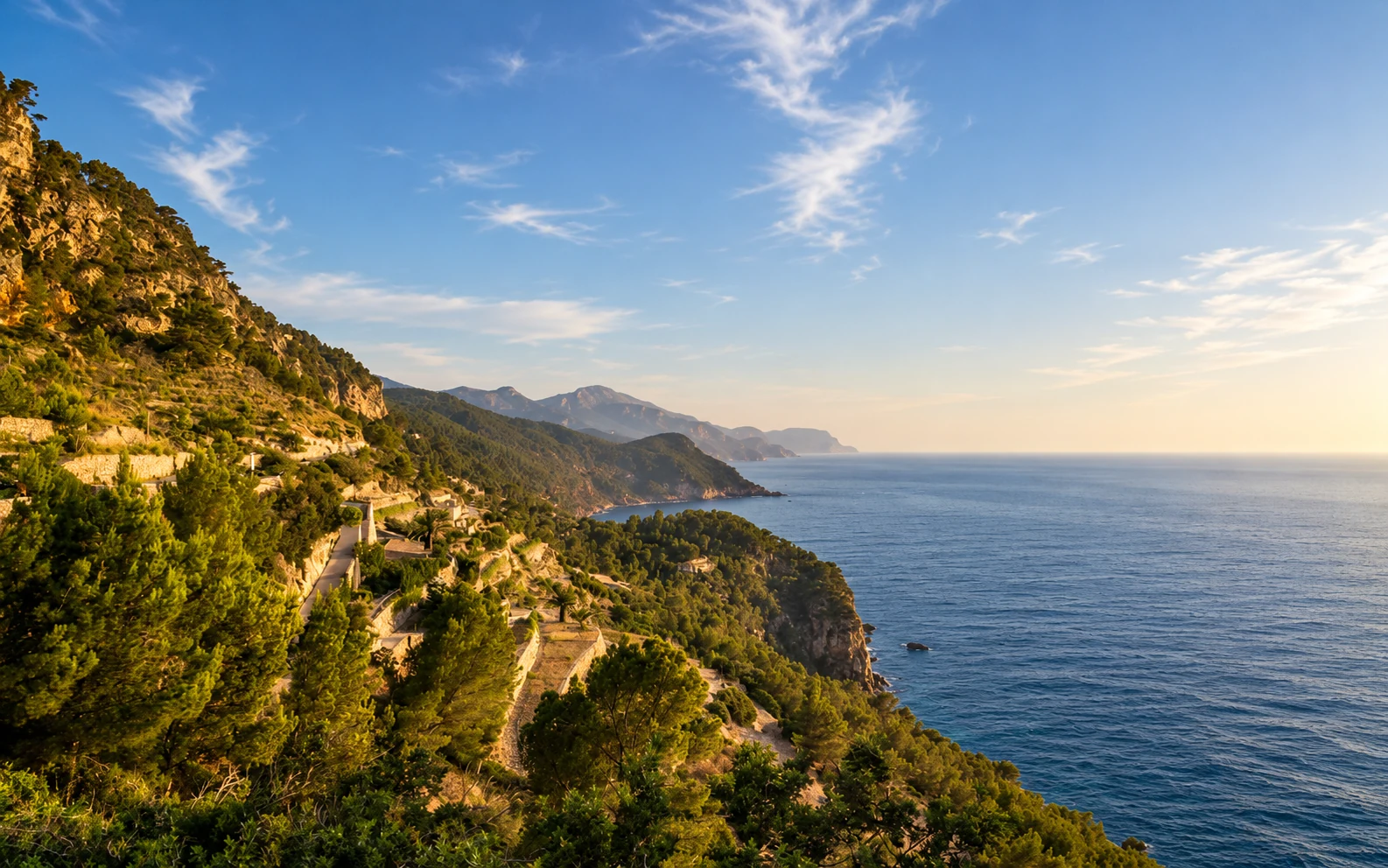 A terraced Mediterranean coastline at sunset
